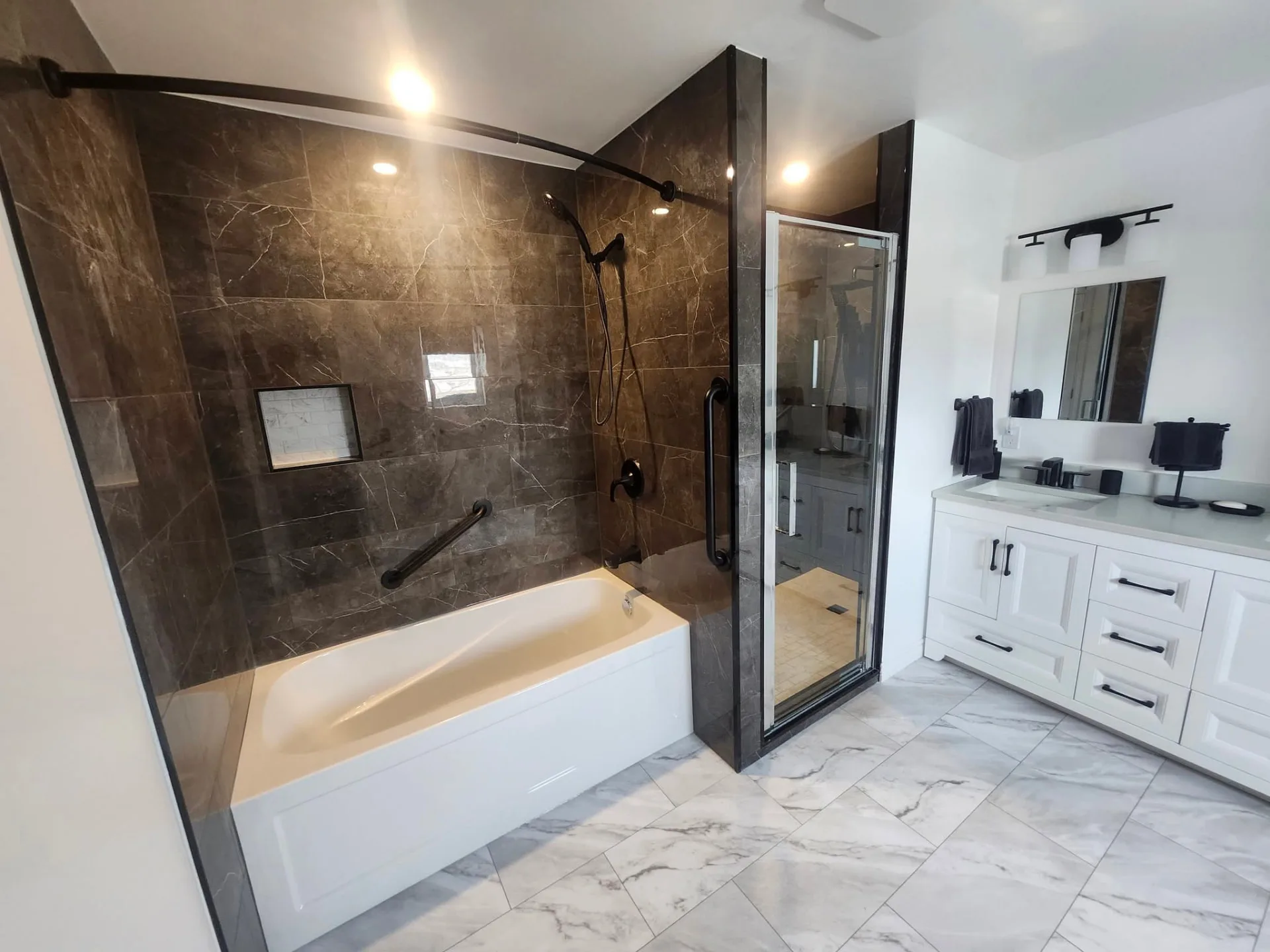 Completed bathroom with dark tile and glass shower